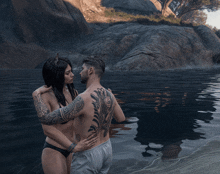 a man and a woman are standing in the water and the woman has horns on her head