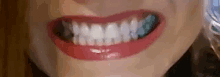 a close up of a woman 's mouth with her teeth visible .