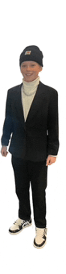 a man wearing a suit and a beanie is standing in front of a white background .