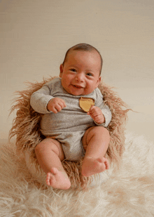 a baby is sitting on a furry blanket and smiling for the camera