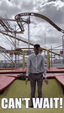 a man standing on a trampoline in front of a roller coaster with the words can 't wait below him