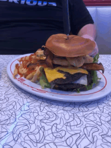 a hamburger and french fries on a plate with a knife on the table