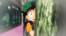 a young boy is peeking out from behind a tree trunk .