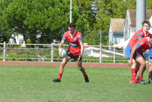 a rugby player in a red jersey with rakuten on it