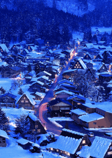 a snowy village at night with a few houses lit up