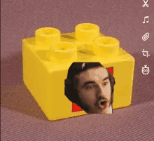 a yellow lego block with a picture of a man in headphones on it