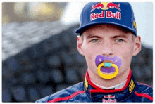 a man wearing a red bull hat and pacifier in his mouth