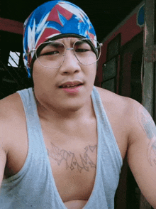 a man wearing glasses and a bandana has a tattoo on his chest that says ' yank ' on it