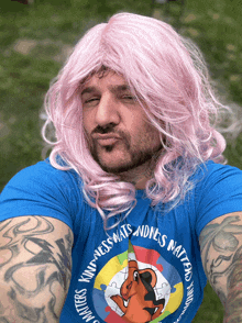 a man in a pink wig is wearing a blue shirt that says kindness matters