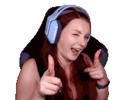 a woman with red hair is wearing headphones and giving a thumbs up