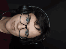 a man wearing glasses and headphones looks down at something