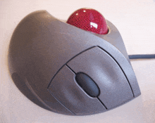 a grey computer mouse with a red ball on top