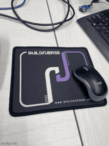 a logitech mouse sits on a mouse pad that says buildverse