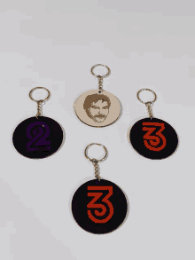 three keychains with the letters n and m on them