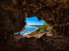 a cave with a view of the ocean in it