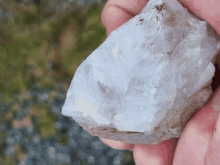 a person is holding a large piece of white rock