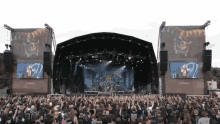 a large crowd of people watching a band on stage with a large screen behind them that says bloodstock open air