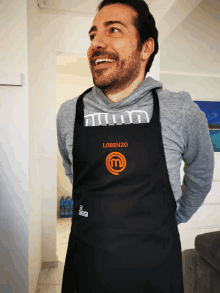 a man wearing a black apron that says lorenzo on it