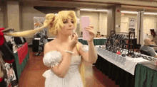 a woman in a white dress is taking a picture of herself in a mirror