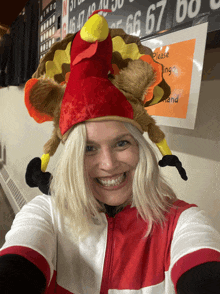 a woman wearing a turkey hat is smiling for the camera