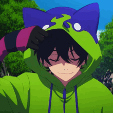 a person wearing a green hoodie with a blue cat ear