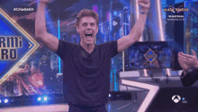 a man stands on a stage with his arms in the air in front of a sign that says " mask singer "