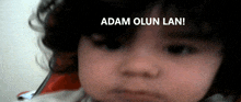 a close up of a child 's face with the words adam olsun lan written above it