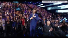 a man in a suit is standing in front of a crowd and a sign that says " the best fifa football awards 2016 full show "