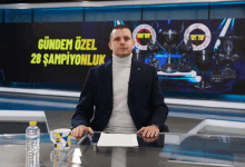 a man sits at a desk in front of a sign that says gündem özel 28 şampiyonluk