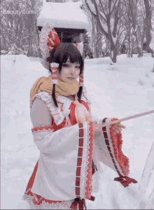 a woman in a red and white costume is standing in the snow with beauty cam written on the bottom right