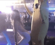 a woman in a white dress is dancing in front of a banana costume