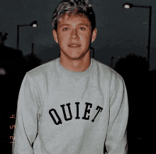 a young man is wearing a sweater that says quiet