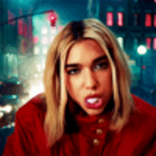 a woman in a red jacket is looking at the camera with her mouth open .