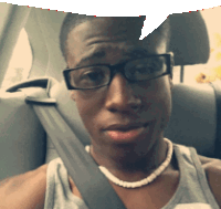 a man wearing glasses and a pearl necklace sits in a car