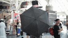 a man in a top hat is holding an umbrella in front of a sign that says state of california