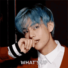 a young man with blue hair is making a face and the words what 's up are visible