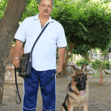 a man is standing next to a german shepherd dog