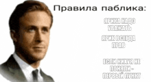 a man in a suit and tie stands in front of a white background with russian writing