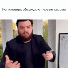 a man with a beard is giving a presentation in front of a whiteboard that says " новые страты "