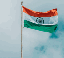 an indian flag is flying in the wind against a blue sky