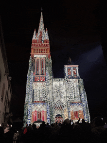 a large building with a steeple and a clock tower is lit up