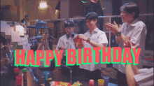 a group of young men are celebrating a birthday in a room with the words happy birthday written above them .