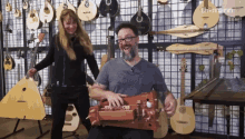 a man playing a musical instrument in front of a wall of musical instruments and a sign that says th-mann