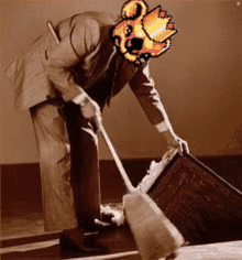 a man in a suit is cleaning the floor with a broom and has a pixelated image of a fireball on his head .