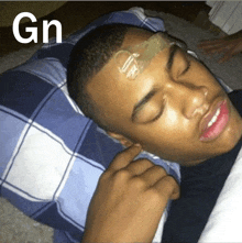 a man is laying in bed with a gn sticker on his head