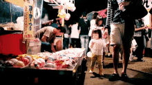 a little girl stands in front of a display of balloons and a sign that says ' yoyo ' on it