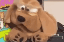 a stuffed dog is sitting on a table with a loading bar in the corner .