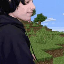 a man wearing headphones is standing in front of a minecraft scene