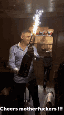 a man is opening a bottle of champagne with a sparkler and the caption cheers motherfuckers !!