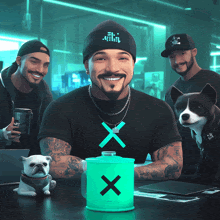 a man wearing a black shirt with an x on it sits at a table with two dogs